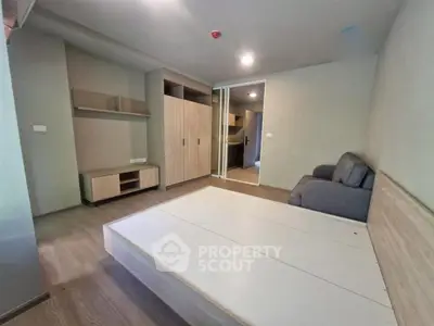 Modern living room with sleek furniture and neutral tones, featuring a cozy sofa and built-in storage solutions.