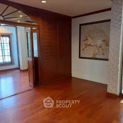 Elegant interior with wooden flooring and decorative wall paneling in a spacious room