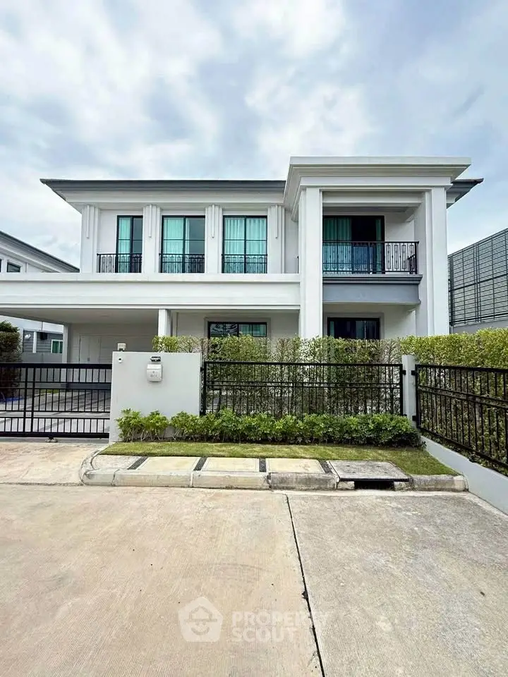 Elegant modern two-story house with a spacious driveway and lush greenery, perfect for family living.