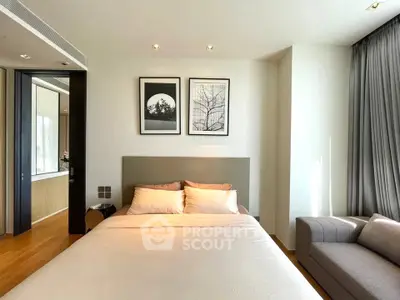 Modern bedroom with elegant decor and natural light, featuring a cozy bed and stylish artwork.