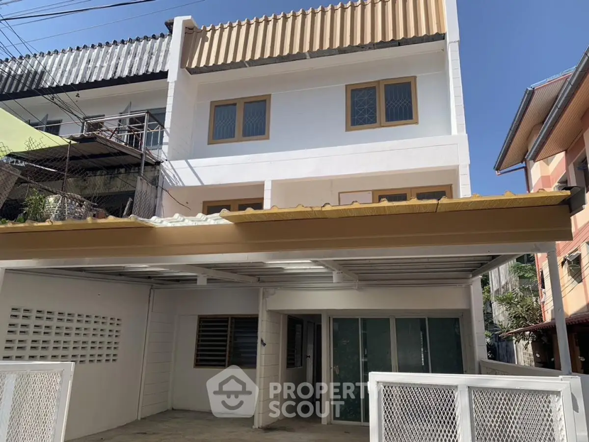Charming three-story townhouse with modern facade and spacious driveway in a serene neighborhood.