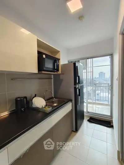 Modern kitchen with sleek appliances and city view from balcony.