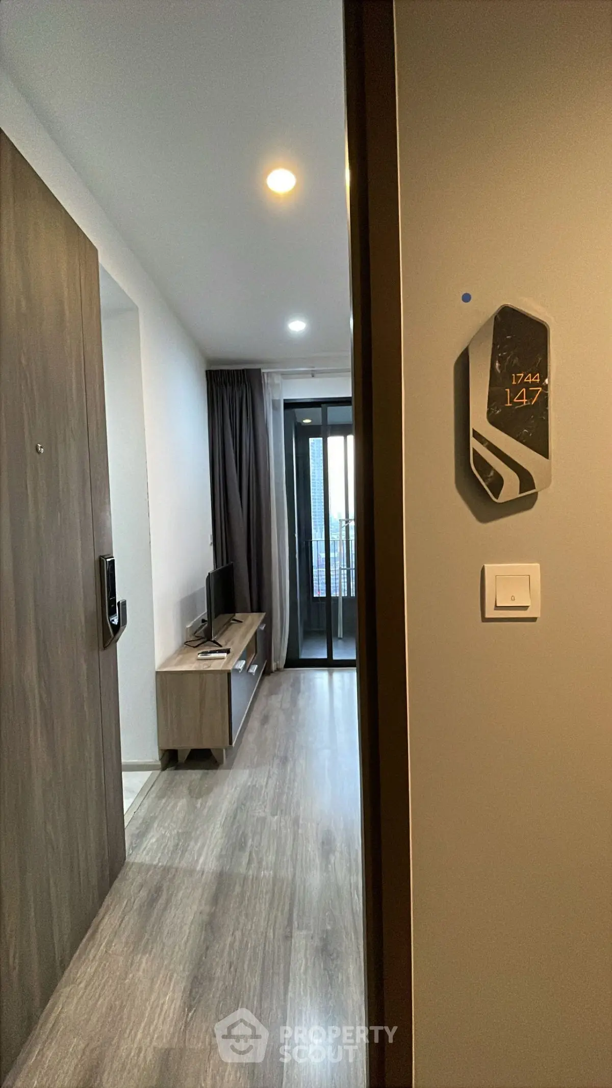 Modern apartment entrance with sleek flooring and balcony view