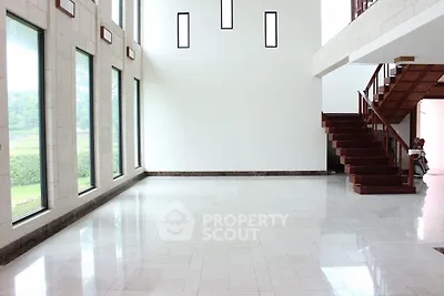 Spacious modern interior with large windows and elegant staircase