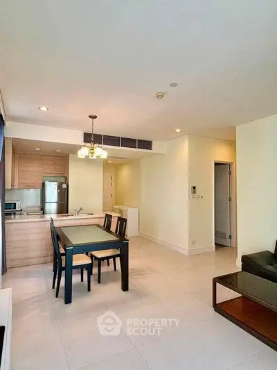 Modern open-layout living room with dining area and kitchen in a bright apartment.