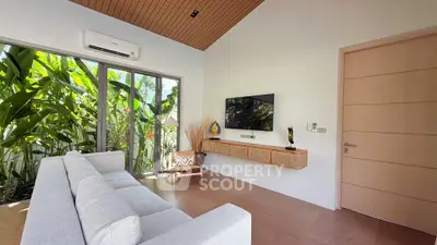 Modern living room with large windows and lush garden view, featuring sleek furniture and wooden accents.