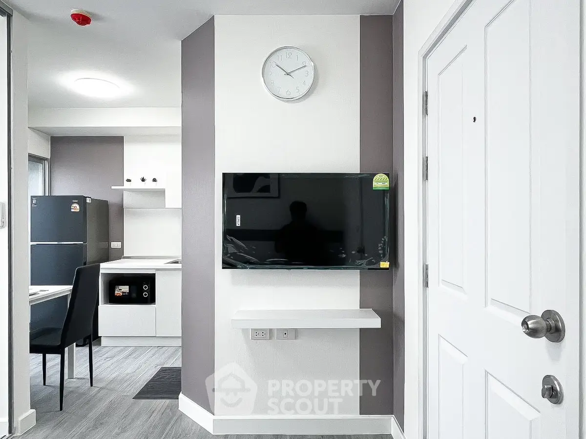 Modern apartment interior with sleek kitchen and wall-mounted TV