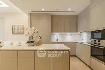 Modern kitchen with sleek cabinetry and built-in appliances, featuring a spacious island and elegant decor.