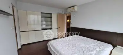 Spacious bedroom with modern built-in wardrobe and air conditioning unit.
