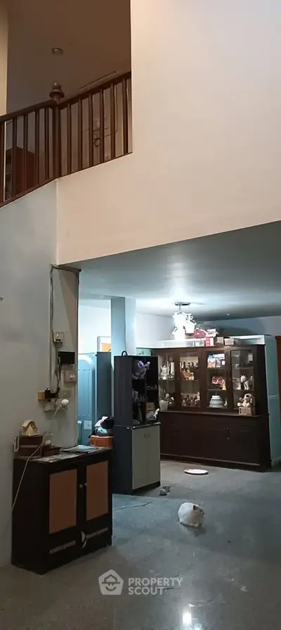 Spacious living room with high ceiling and elegant wooden staircase