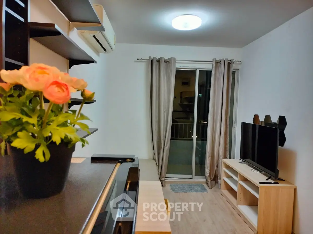 Modern living room with balcony access, featuring sleek furniture and ambient lighting.