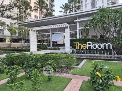 Modern condominium entrance with lush landscaping and water feature at The Room.