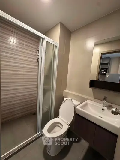 Modern bathroom with shower and sleek vanity in contemporary apartment.