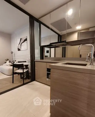 Modern open-layout kitchen with sleek design and adjacent cozy living area.