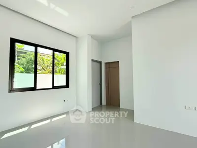 Spacious and bright room with large window and modern design, perfect for customization.