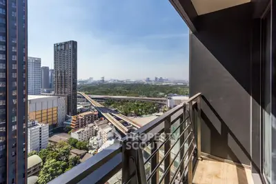Stunning high-rise balcony with panoramic cityscape and lush greenery views.