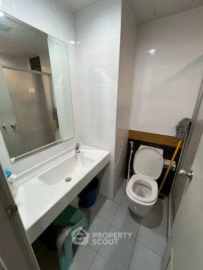Compact modern bathroom with white tiles and sleek fixtures
