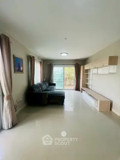 Spacious living room with modern sofa and large windows for natural light.