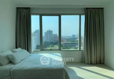 Spacious bedroom with panoramic city view and natural light