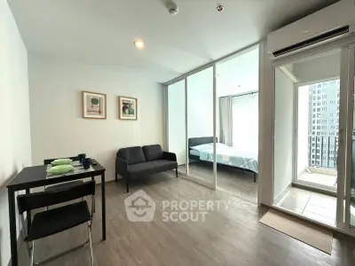 Modern apartment with open living room and bedroom, featuring sleek furniture and large windows for natural light.