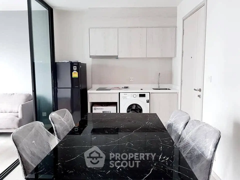 Modern kitchen with sleek black marble dining table and built-in appliances in a stylish apartment.