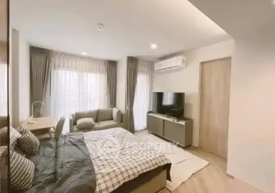 Modern bedroom with cozy decor and natural light in a stylish apartment.