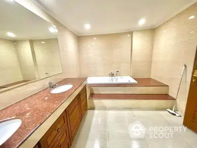 Luxurious bathroom with elegant bathtub and dual sinks in modern real estate property.