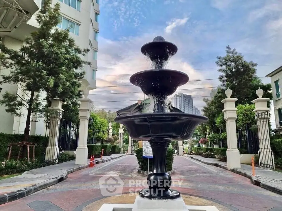 Elegant entrance with a stunning fountain in a luxurious residential complex.