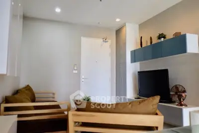 Modern living room with stylish furniture and wall-mounted TV in a cozy apartment.