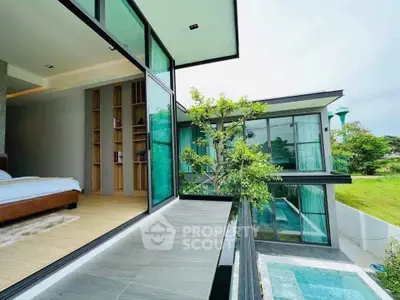 Luxurious modern home with spacious balcony and pool view, featuring sleek glass design and lush greenery.