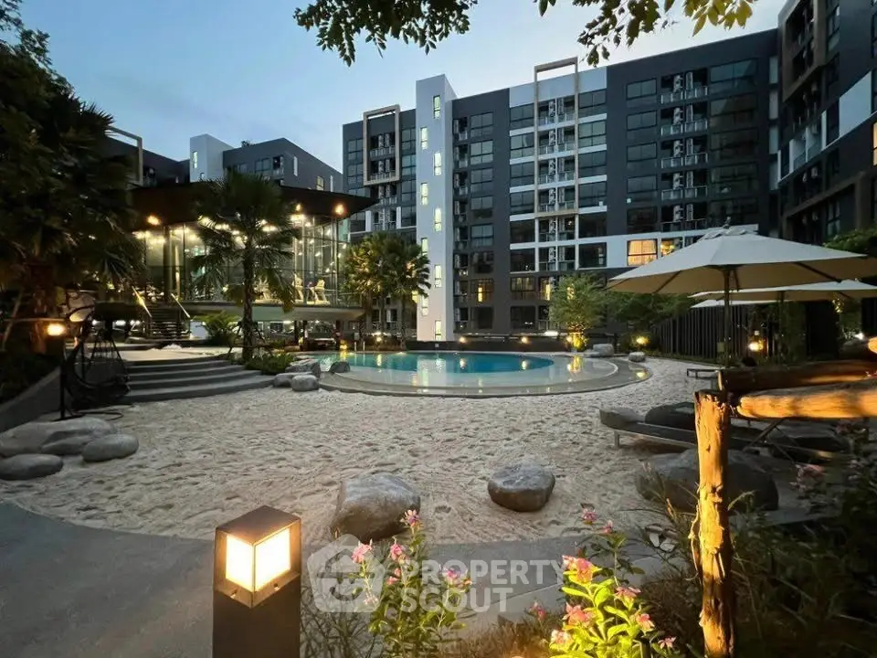 Luxurious apartment complex with stunning pool and landscaped garden at dusk.