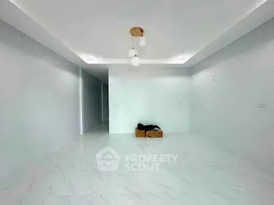 Spacious minimalist living room with modern lighting and marble flooring