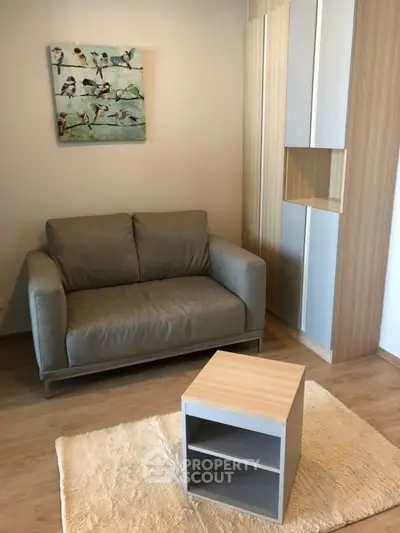 Cozy living room with modern sofa, stylish wall art, and sleek wooden furniture.