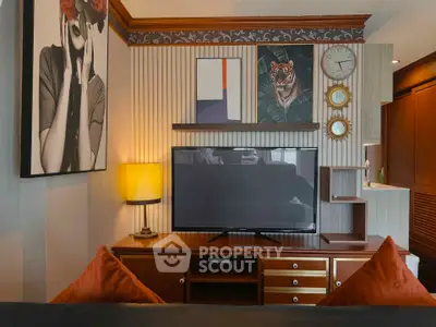 Stylish living room with modern decor and large TV, perfect for relaxation and entertainment.