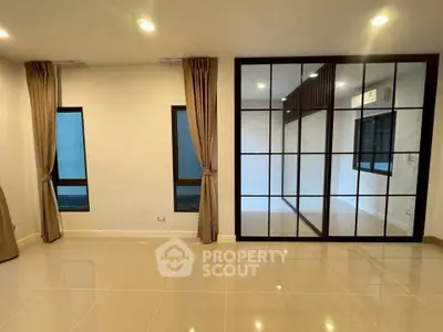 Spacious modern living room with large windows and elegant tile flooring