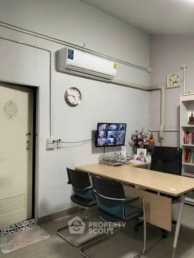 Modern office space with air conditioning and CCTV, featuring a sleek desk and comfortable chairs.