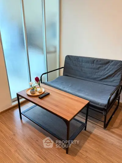 Cozy living room with modern sofa and wooden coffee table, perfect for relaxation.