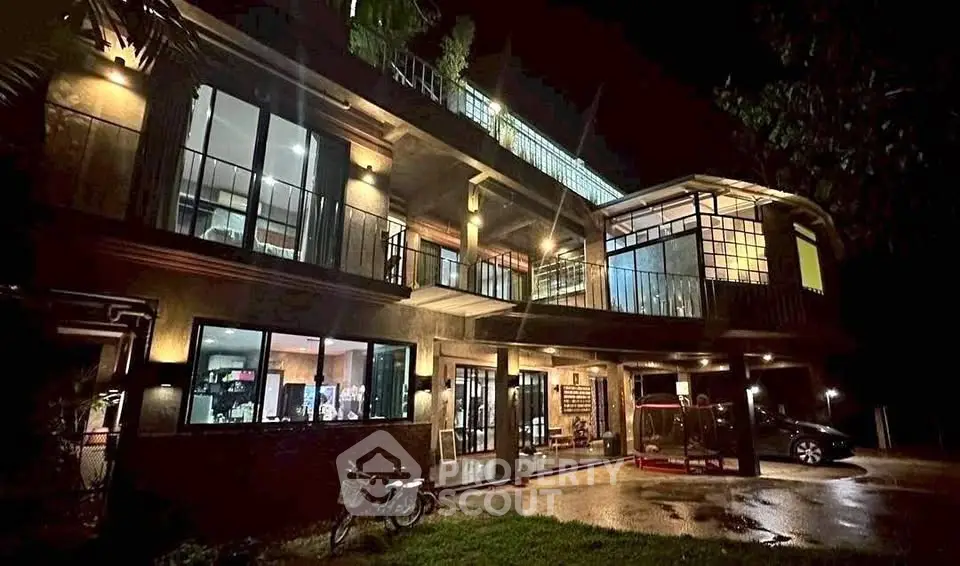 Stunning modern home exterior with expansive windows and ambient lighting at night.