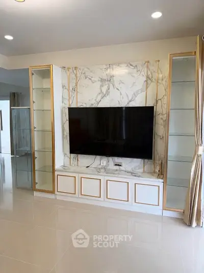 Luxurious living room with elegant marble TV wall and glass shelving, perfect for modern home entertainment.