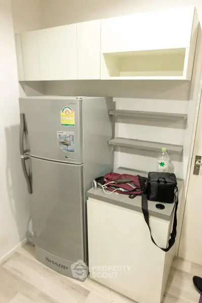 Modern kitchen with sleek fridge and ample storage space, perfect for urban living.