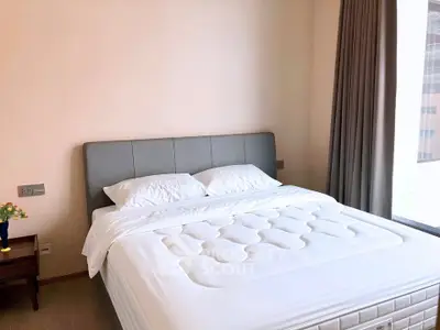 Spacious bedroom with modern decor and large window offering natural light.