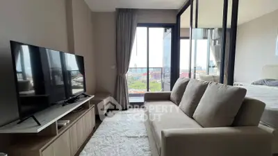 Modern living room with large TV and cozy sofa, featuring a stunning city view from the balcony.