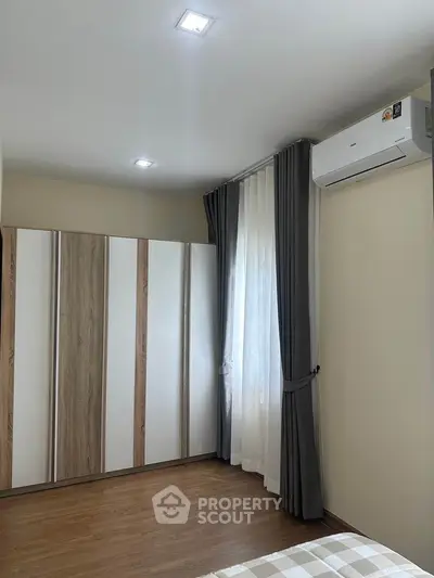 Modern bedroom with stylish wardrobe and air conditioning in a cozy apartment.