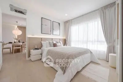 Elegant bedroom with modern decor and natural light, featuring cozy bedding and stylish artwork.