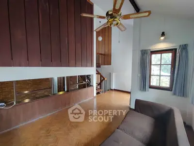 Spacious living room with wooden accents and ceiling fan in a cozy home.