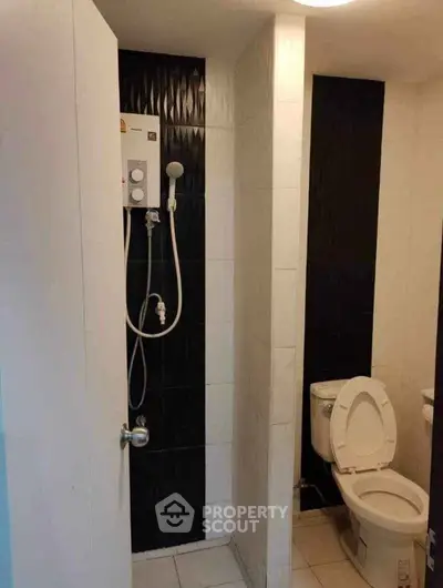 Compact bathroom with modern shower and toilet in sleek black and white design.