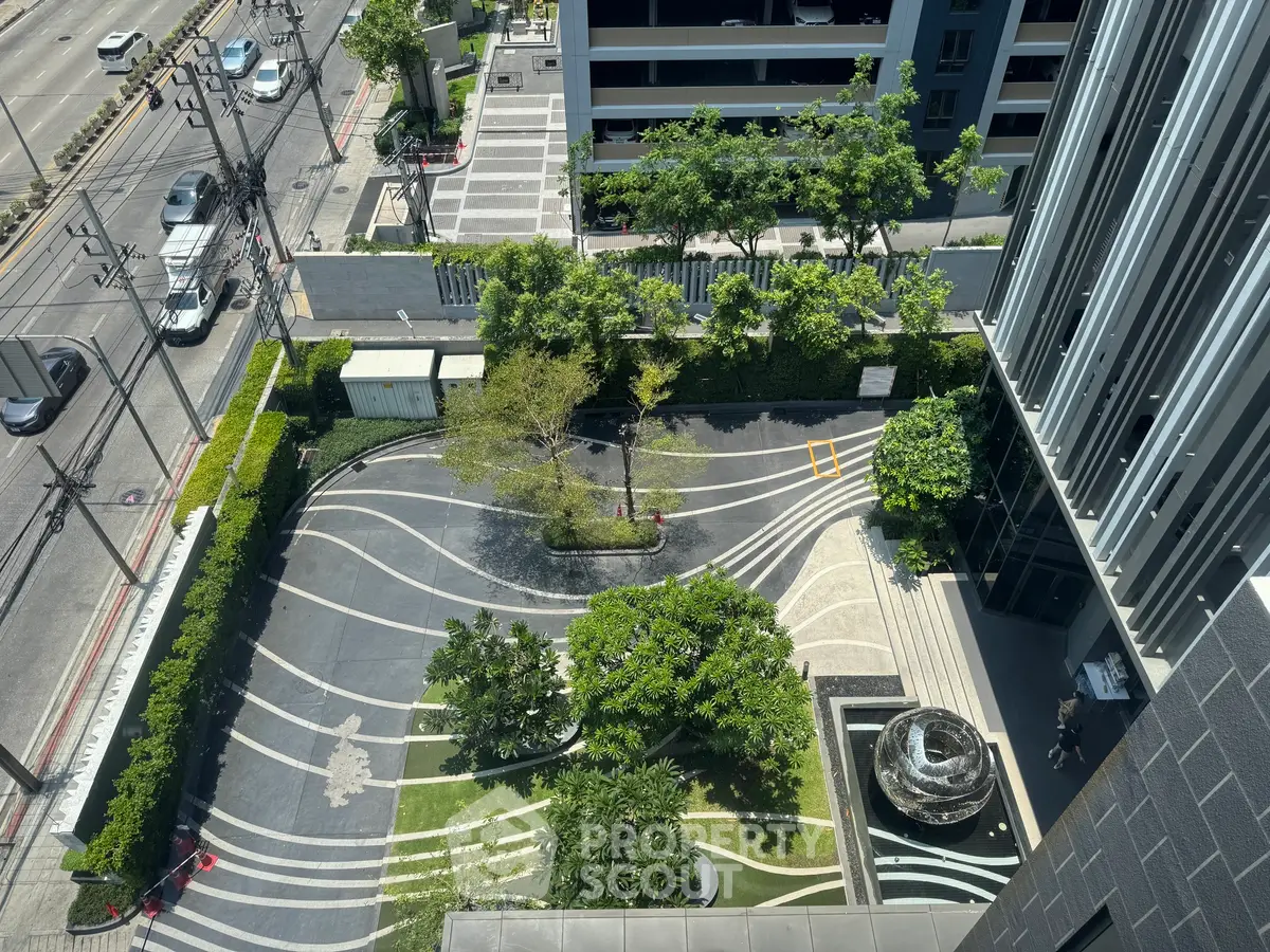Stunning aerial view of modern building entrance with lush landscaping and unique design elements.