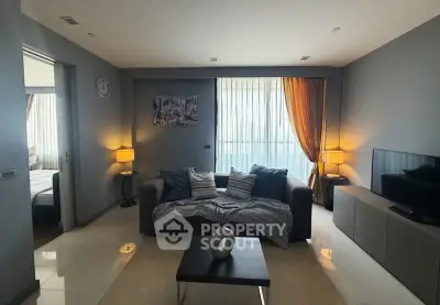 Modern living room with cozy sofa, stylish decor, and natural light from large window.
