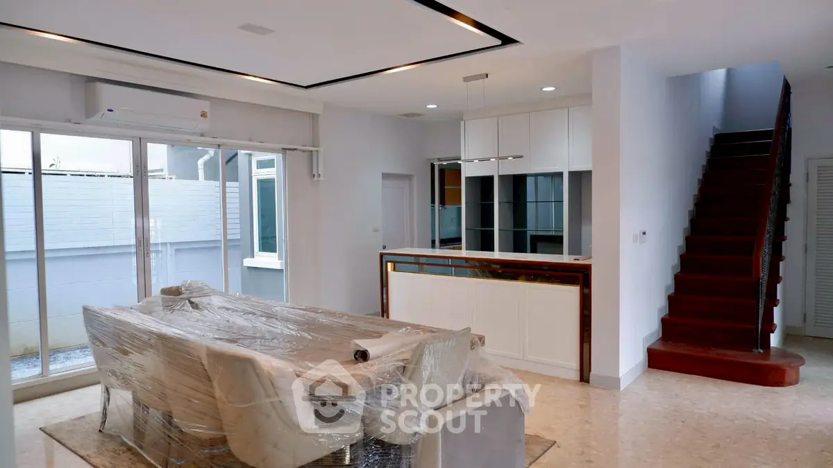 Spacious modern dining area with open kitchen and staircase in elegant home