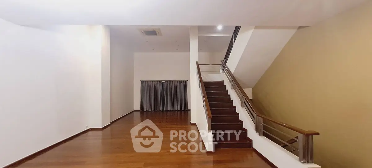 Spacious modern living room with elegant wooden staircase and sleek flooring